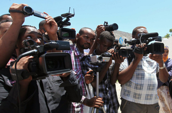 Somali journalists demonstrate against an article appearing in the British paper The Guardian calling them corrupt, in capital Mogadishu October 18, 2012. A journalist holds up a picture of the article's author Jamal Osman (R). REUTERS/Feisal Omar (SOMALIA - Tags: CIVIL UNREST POLITICS)