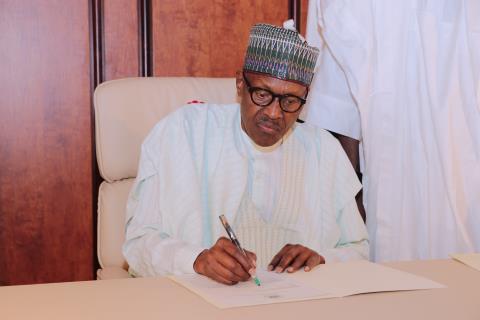 PRESIDENTBUHARI SIGNS HIS LETTER TO NATIONAL ASSEMBLY. President Buhari signs letter notifying the National Assembly of his resumption of duties flanked by the Chief of Staff at the State House Abuja on  Aug 21, 2017. PHOTO; SUNDAY AGHAEZE/STATE HOUSE