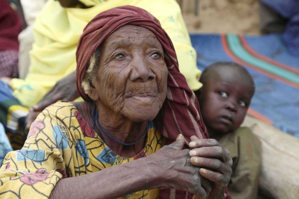 An elderly woman sits on the ground in the recently retaken town of Damasak, Nigeria, March 20, 2015. Soldiers from Niger and Chad who liberated the Nigerian town of Damasak from Boko Haram militants have discovered the bodies of at least 70 people, many with their throats slit, scattered under a bridge, a Reuters witness said. REUTERS/Emmanuel Braun