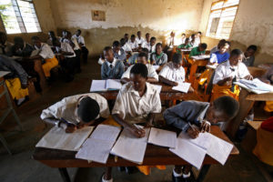 Kampala, UGANDA: Students at St. Denis' Secondary School in Ggaba, a suburb of the capital Kampala, study during the first lesson of the day 23 March 2007. The Ugandan government has recently launched the Universal Secondary Education (USE) programme which enables pupils at certain schools to attend the first year of secondary education free from school fees, with the initiative designed to provide further free schooling through the remaining years of secondary education. AFP PHOTO / STUART PRICE (Photo credit should read STUART PRICE/AFP/Getty Images)