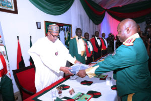 PRESIDENT BUHARI ATTENDS ARMY REGIMENTAL DINNER 00B. BH FLAG/QURAN: The Chief of Defence Staff, General Abayomi Olonisakin Hands over Boko Harem flag and Shekau's Qur'an captured in Sambisa forest by the Nigeria Army to President Muhammadu Buhari during the 2016 Regimental dinner night with Guards Brigade in Abuja. PHOTO; SUNDAY AGHAEZE. DEC 30 2016