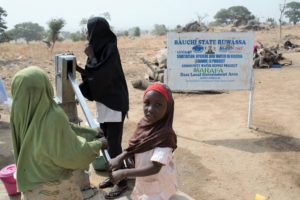 Girls collect water from a “Hand Pump Bore Hole” in Marafa Community in the Zumbul Ward in Bauchi state in Nigeria on February 7, 2016. With the efforts of the WASHCOM program Marafa Community has been certified as a Open Deification Free community with all households having access to latrines and hand washing facilities close to their latrines, hygiene promotion sessions have also empowered women and strengthen family ties through safe menstrual hygiene management practises.